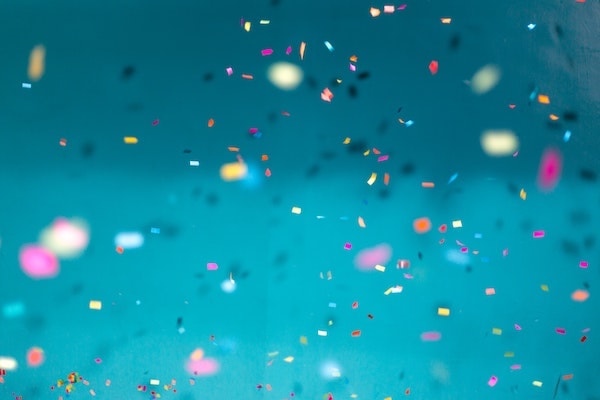 Falling confetti in front of turquoise background